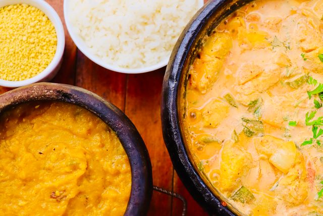 Moqueca brasileña con pescado o camarones en salsa cremosa, acompañada con arroz blanco y farofa.