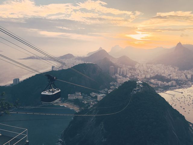 Teleférico del Pan de Azúcar en Río de Janeiro con niños Teleférico del Pan de Azúcar sobre Río de Janeiro al atardecer, con las playas, montañas y la ciudad al fondo.