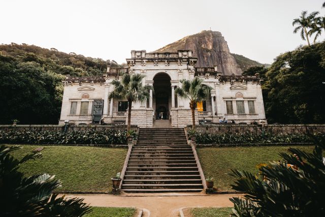 Parque Lage en Río de Janeiro con niños Palacete del Parque Lage en Río de Janeiro, rodeado de jardines y vegetación, con el Corcovado al fondo.
