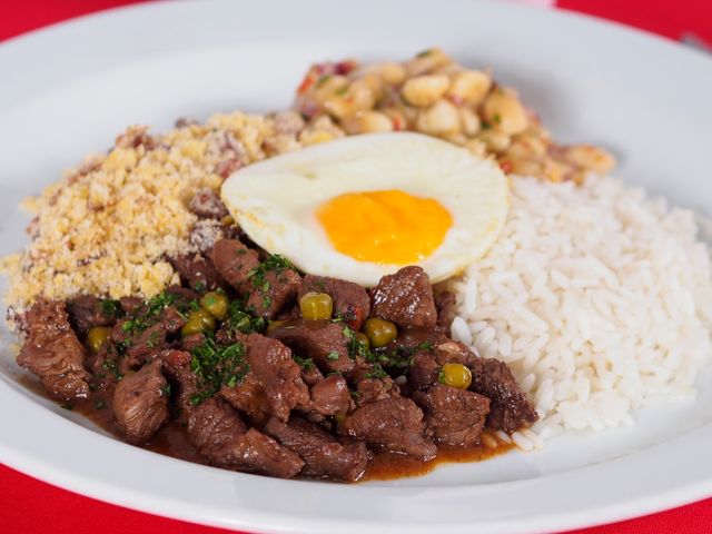 Picadinho brasileño con arroz, huevo y farofa Plato brasileño con carne en cubos, arroz blanco, huevo frito, farofa y frijoles.