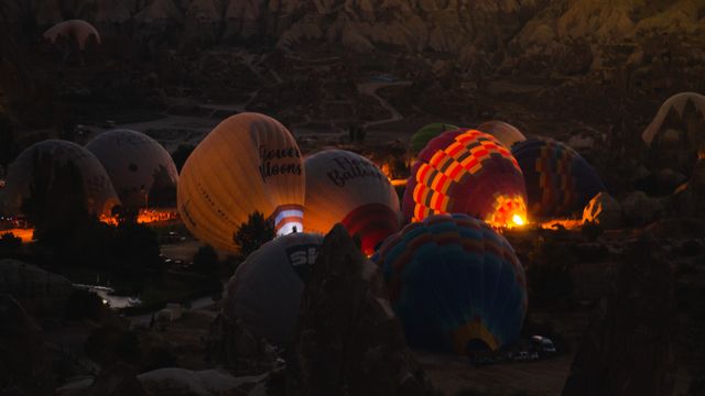 Globos aerostáticos iluminados por sus quemadores durante la preparación de los vuelos al amanecer en Capadocia, Turquía.