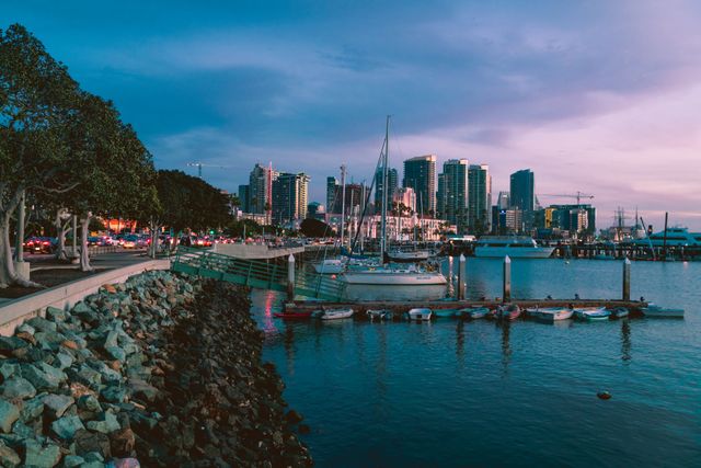 San Diego, destino de clima templado en invierno en Estados Unidos Puerto de San Diego, California, con veleros y edificios del centro al atardecer durante una jornada de clima templado.