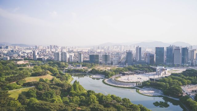 Seúl entre las ciudades más atractivas del mundo en 2026 Vista panorámica de Seúl, Corea del Sur, con áreas verdes, un lago y el skyline de la ciudad al fondo.