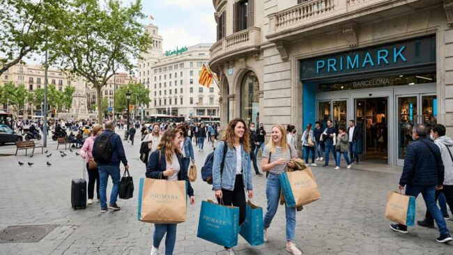 Tienda Primark en Barcelona: ubicación y cómo llegar Compradoras con bolsas frente a una tienda Primark en una zona céntrica y concurrida de Barcelona.
