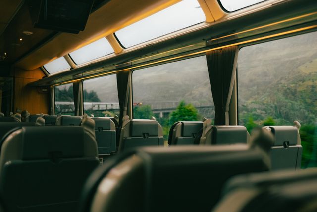 Interior panorámico del tren TranzAlpine en Nueva Zelanda, con amplias ventanas y vistas al paisaje montañoso durante el recorrido.