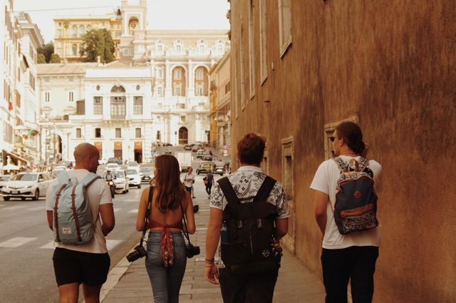 Grupo de jóvenes turistas caminando y conversando por una ciudad europea durante un viaje.