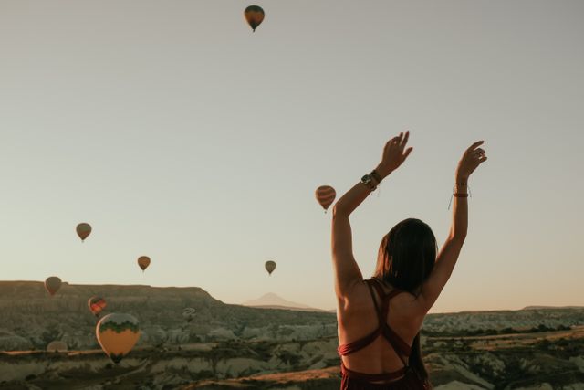 Viajera observa globos aerostáticos sobre los valles de Capadocia al amanecer, en Turquía.