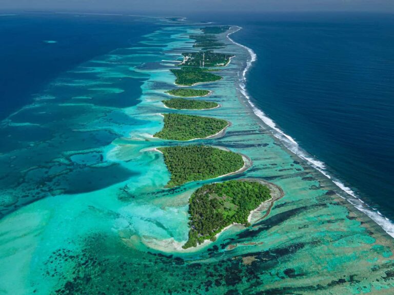 Vista aérea de una cadena de pequeñas islas tropicales rodeadas de arrecifes y aguas turquesas