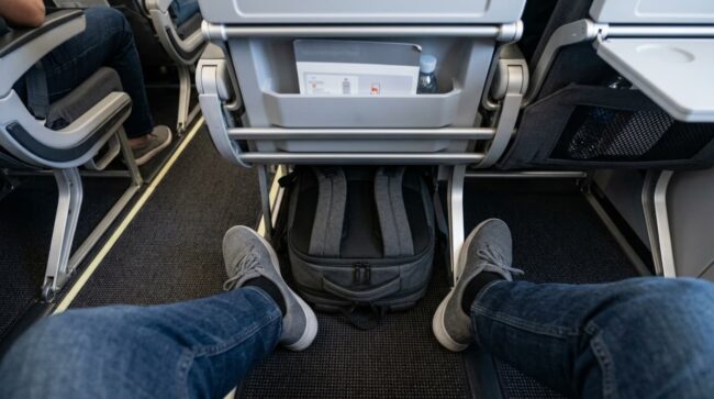 Dónde debe ir el artículo personal durante el vuelo Mochila colocada debajo del asiento delantero de un avión como artículo personal