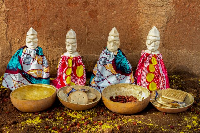 Cultura y tradiciones de Benín en África Occidental Figuras tradicionales vestidas con telas de colores y ofrendas en Benín