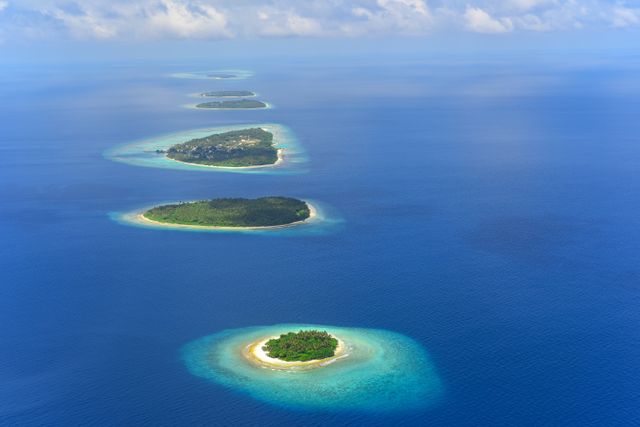 Islas tropicales para viajar en 2026 Vista aérea de pequeñas islas tropicales rodeadas de lagunas turquesas y mar azul