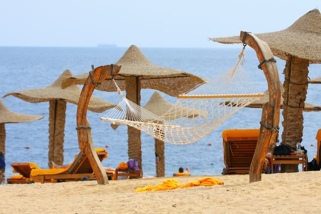 Mejor época para viajar al mar Rojo en Egipto Playa con tumbonas, sombrillas y hamaca junto al mar Rojo en Egipto