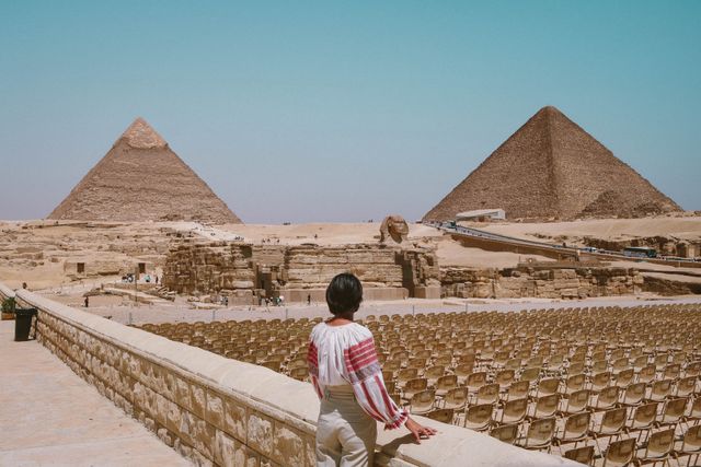 Mejor época para visitar las pirámides de Giza en Egipto Viajera contempla las pirámides de Giza y la Gran Esfinge bajo el sol de Egipto
