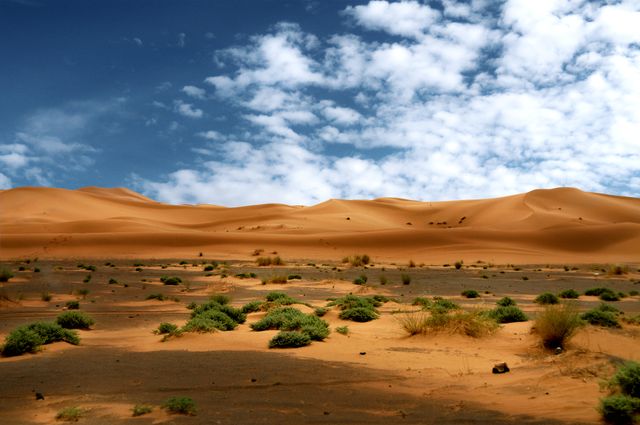 Dunas de arena en el desierto del Sahara de Marruecos bajo un cielo azul con nubes