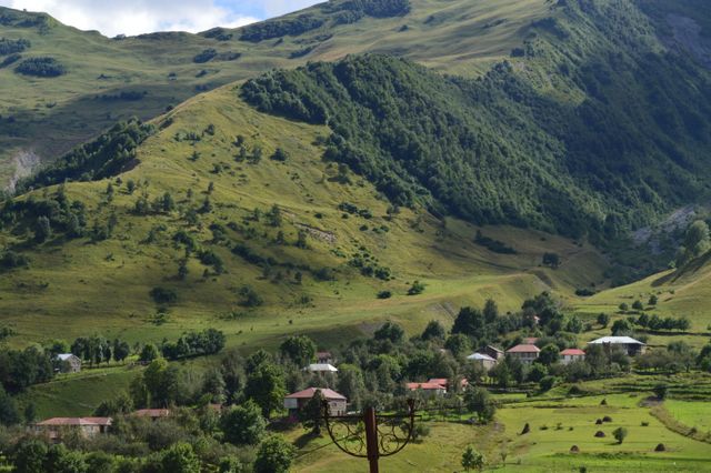 Paisaje de Mestia, en Georgia, con montañas verdes y pequeñas casas en el valle