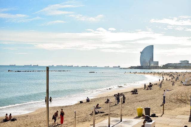 Vivir en Barcelona con voluntariado cerca de sus playas Playa de la Barceloneta en Barcelona con el hotel W al fondo y personas junto al mar