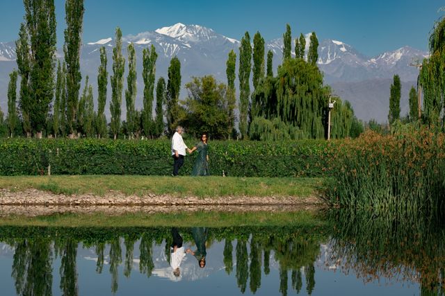 Recorrer bodegas de Mendoza sin auto entre viñedos y la Cordillera Pareja recorre un viñedo de Mendoza con la Cordillera de los Andes al fondo