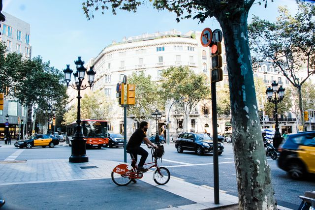 Vivir en Barcelona con alojamiento y comidas a cambio de voluntariado Ciclista recorre una avenida de Barcelona, ciudad donde ofrecen voluntariado con alojamiento y comidas