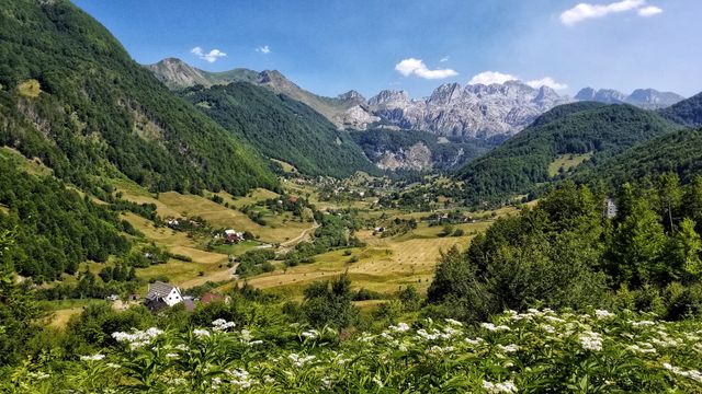 Albania, uno de los destinos más subestimados para viajar en 2026 Valle montañoso de Albania con pueblos, bosques y altas cumbres