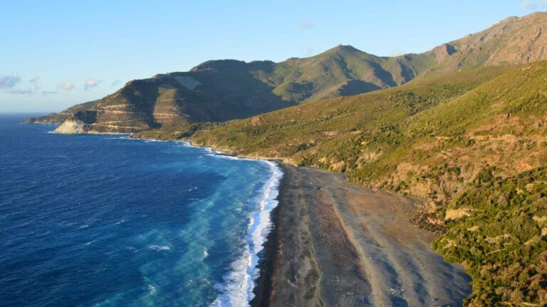 Costa volc&aacute;nica de Cabo Verde con playa oscura, monta&ntilde;as y el oc&eacute;ano Atl&aacute;ntico
