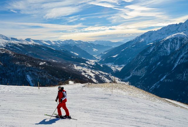 Esquiador en una estación de montaña de Europa rodeada de picos nevados
