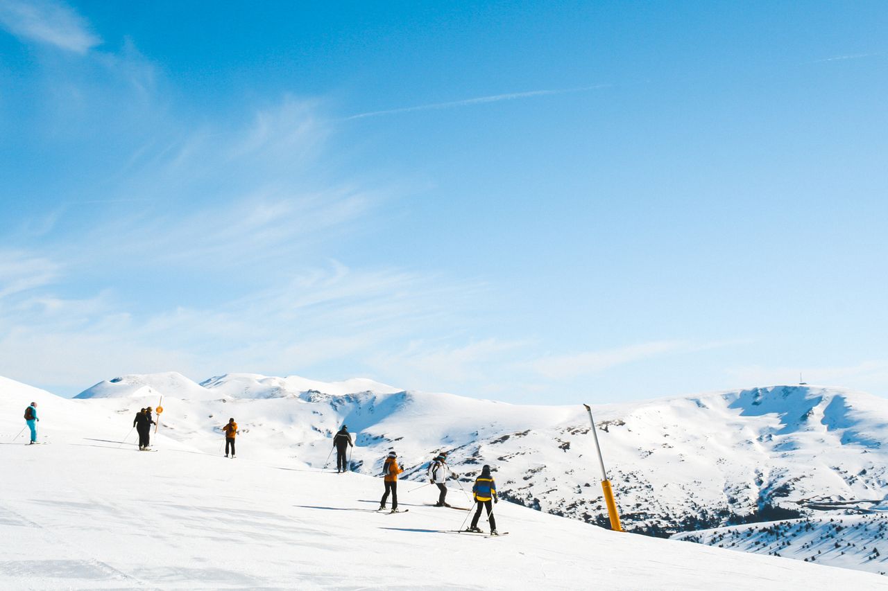 Esquiadores recorren una amplia pista de nieve en una estación de montaña de Europa