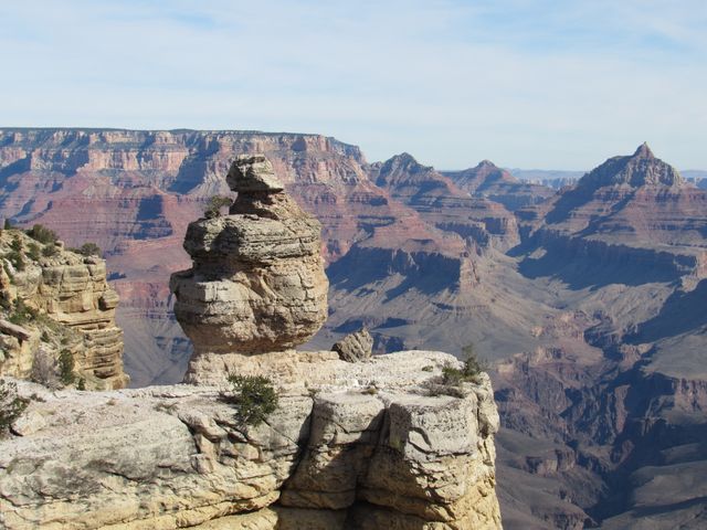 Formación rocosa frente a las paredes y profundos cañones del South Rim del Gran Cañón en Arizona