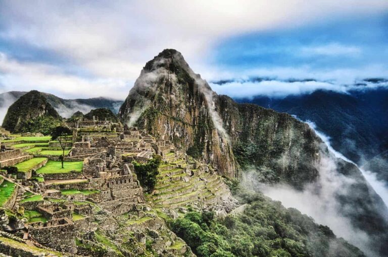 Machu Picchu entre nubes con sus terrazas, construcciones incas y Huayna Picchu al fondo