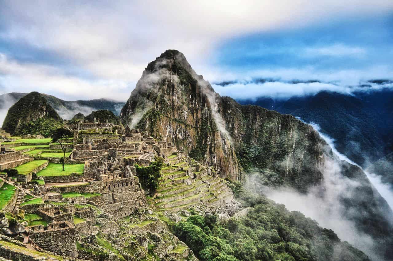 Machu Picchu entre nubes con sus terrazas, construcciones incas y Huayna Picchu al fondo