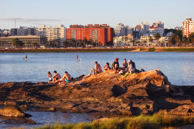 Montevideo, Uruguay: calidad de vida y retiro en 2026 Personas descansan junto a la costa de Montevideo con edificios y la rambla al fondo