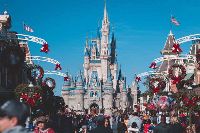 Magic Kingdom en Orlando decorado para Navidad con coronas, lazos rojos y el Castillo de Cenicienta al fondo