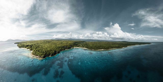 Vanuatu, uno de los destinos más subestimados para viajar en 2026 Vista aérea de una isla de Vanuatu rodeada de arrecifes y aguas turquesas en el Pacífico Sur